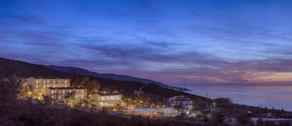 a town on top of a hill at night at Karras Star Hotel in Évdhilos