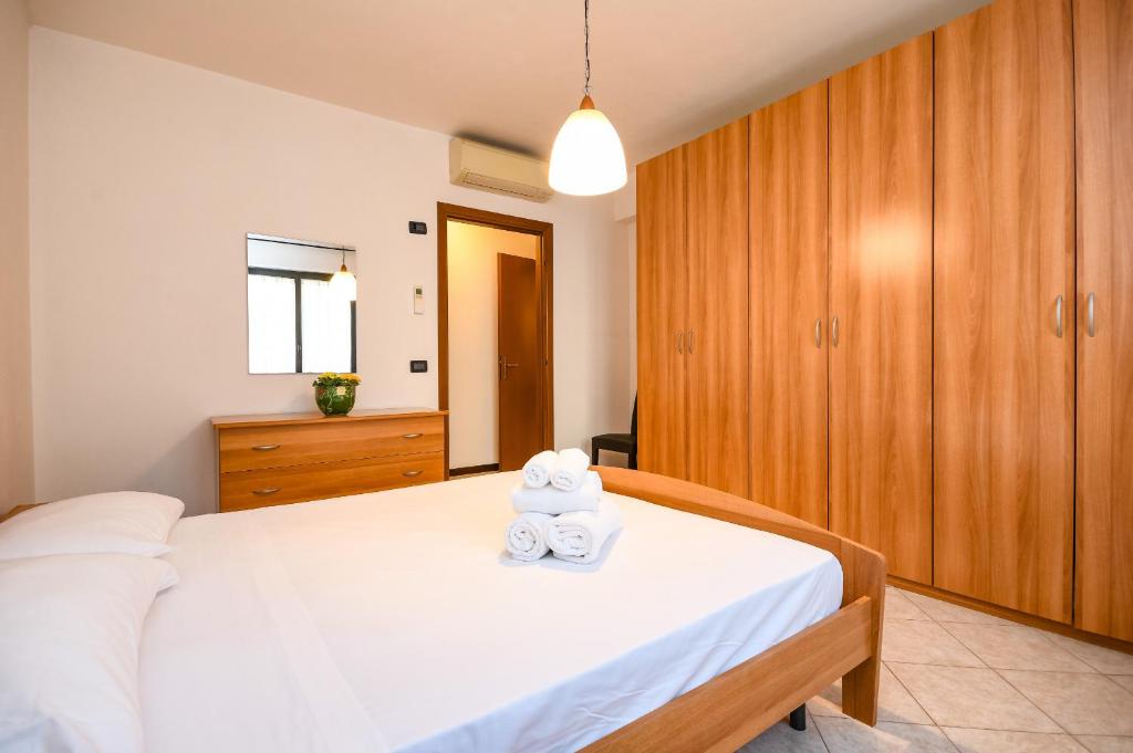 een slaapkamer met een bed met twee handdoeken erop bij DesenzanoLoft Yellow Apartment in Desenzano del Garda
