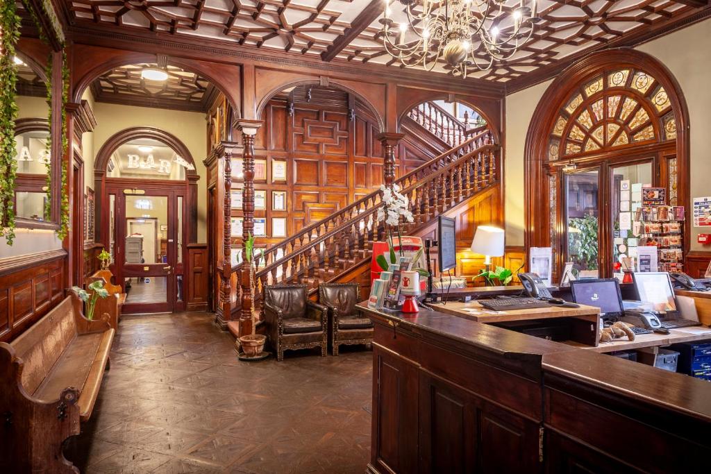 a bar in a room with a staircase in a building at Palmers Lodge Swiss Cottage in London
