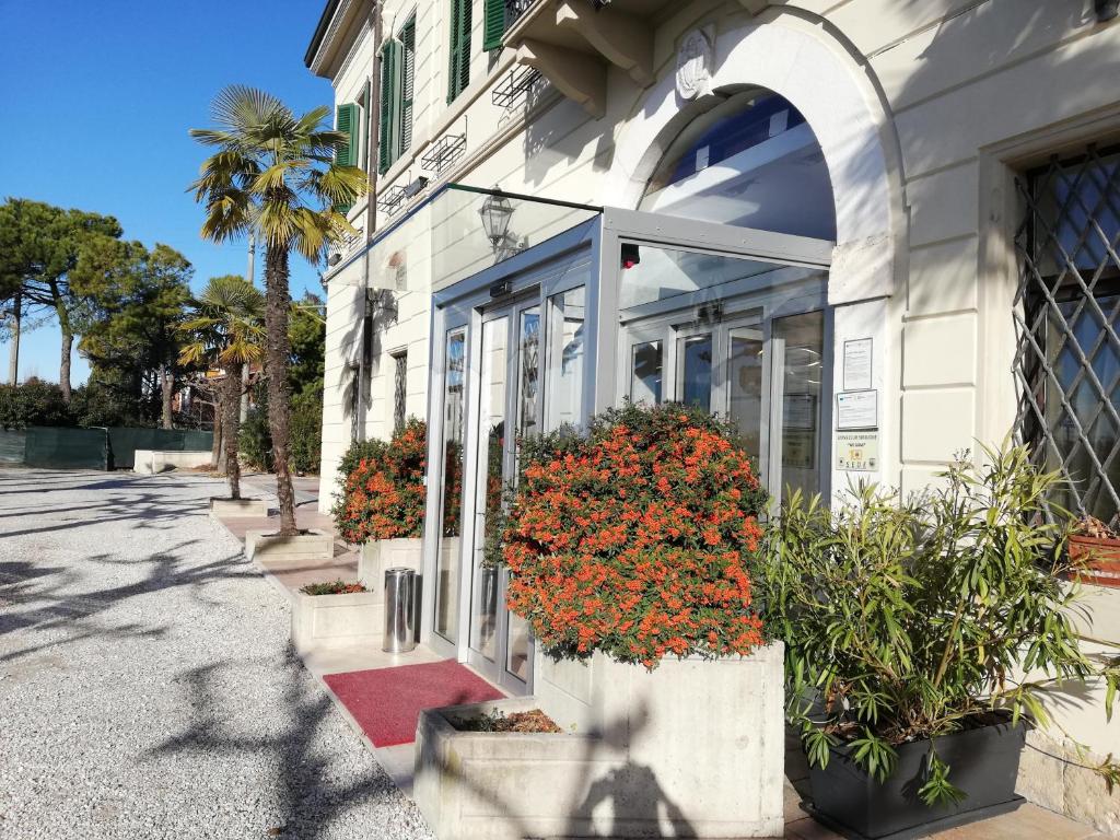 ein weißes Gebäude mit Blumen im Fenster in der Unterkunft Hotel Dogana in Sirmione