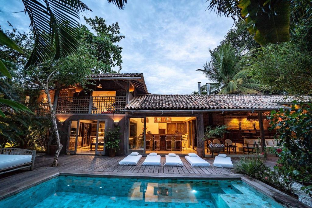 a house with a swimming pool in front of a house at Casa Angatu in Trancoso