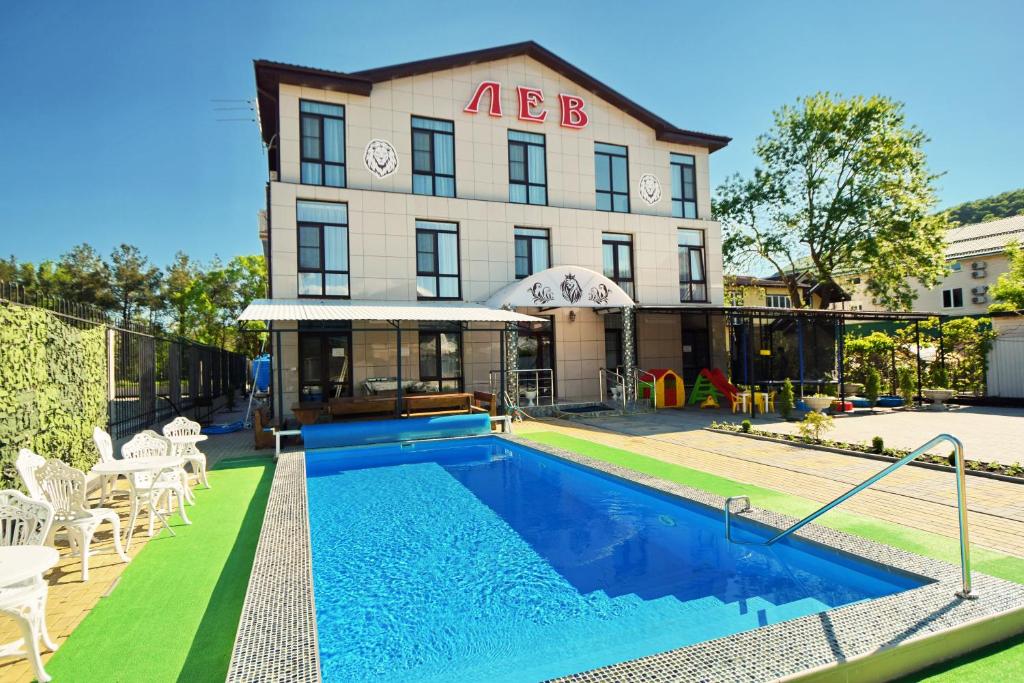 a house with a swimming pool in front of a building at Lev in Arkhipo-Osipovka