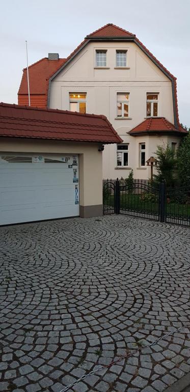 a brick driveway in front of a house with a garage at Ferienwohnung Stadtvilla in Magdeburg