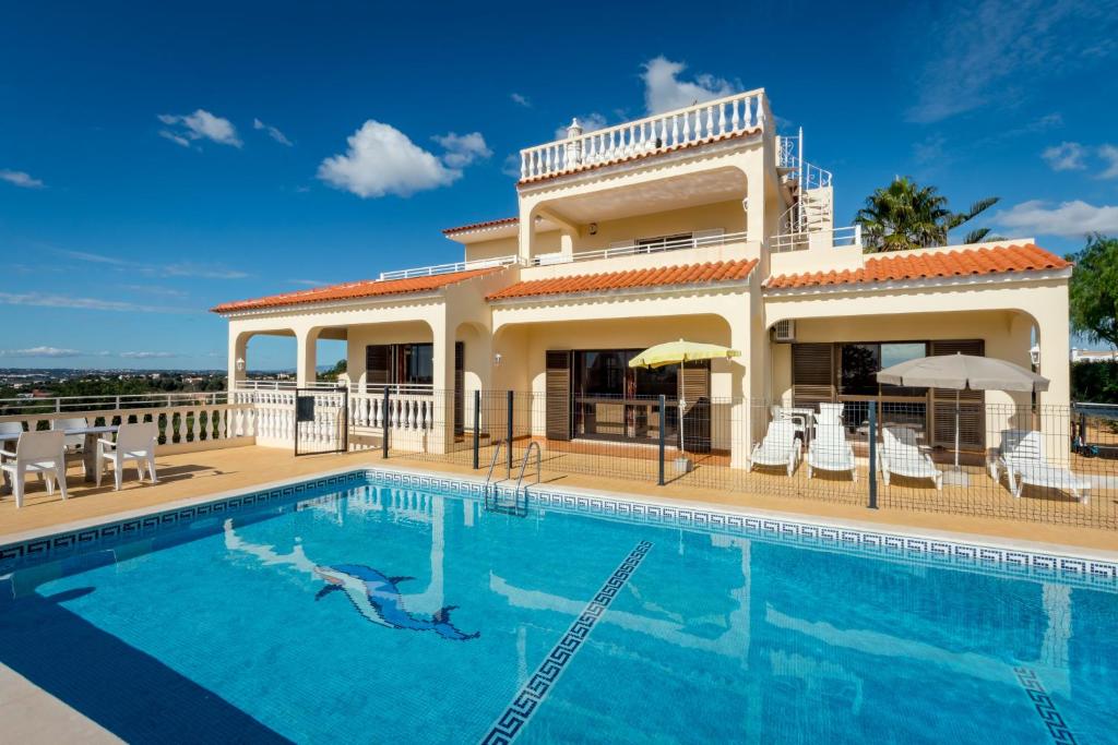 eine Villa mit einem Pool vor einem Haus in der Unterkunft Villa Mirante in Albufeira