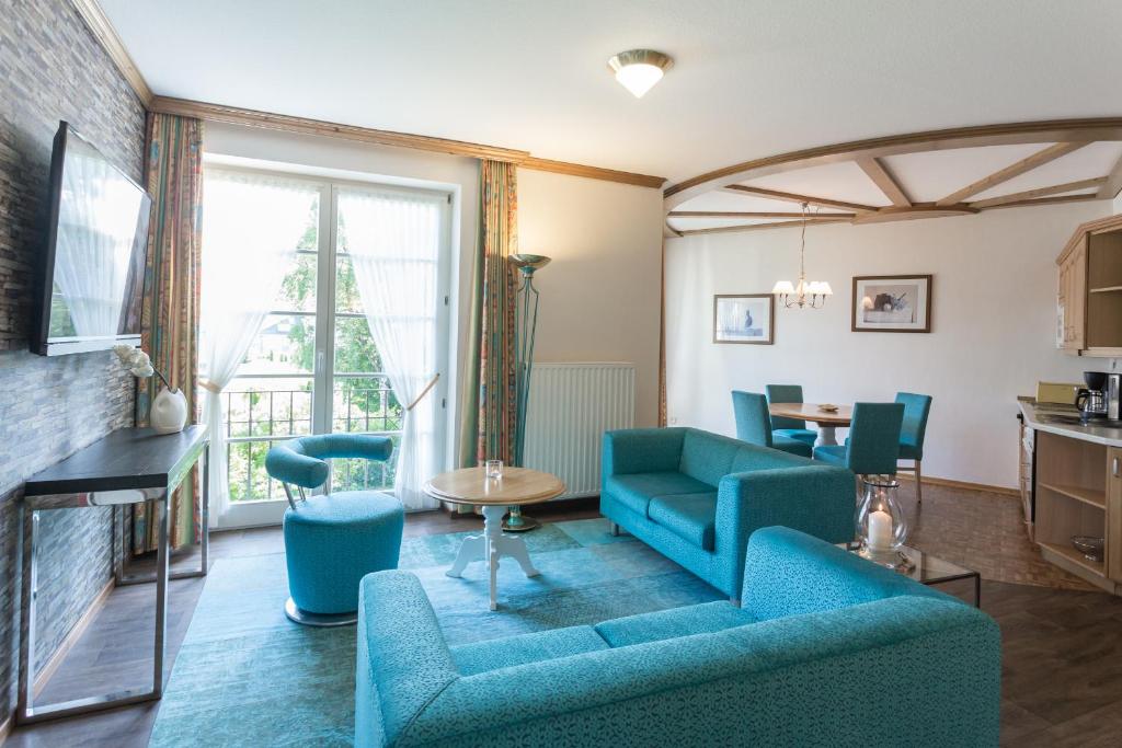 a living room with blue furniture and a fireplace at Villa Katharina Ferienwohnungen in Willingen