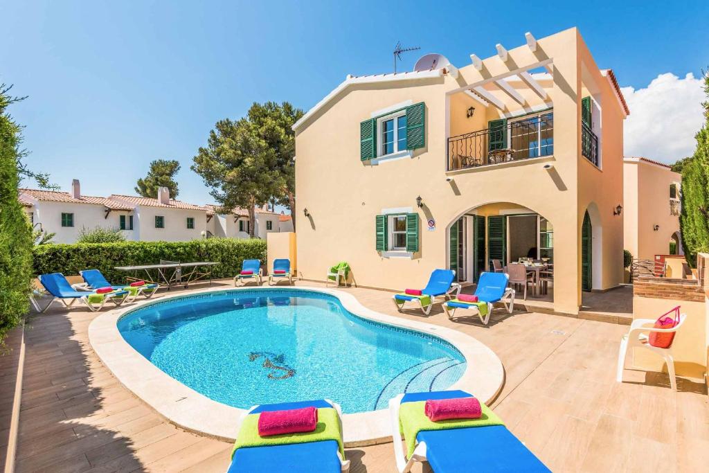 a villa with a swimming pool in front of a house at Villa Alicia in Cala Galdana