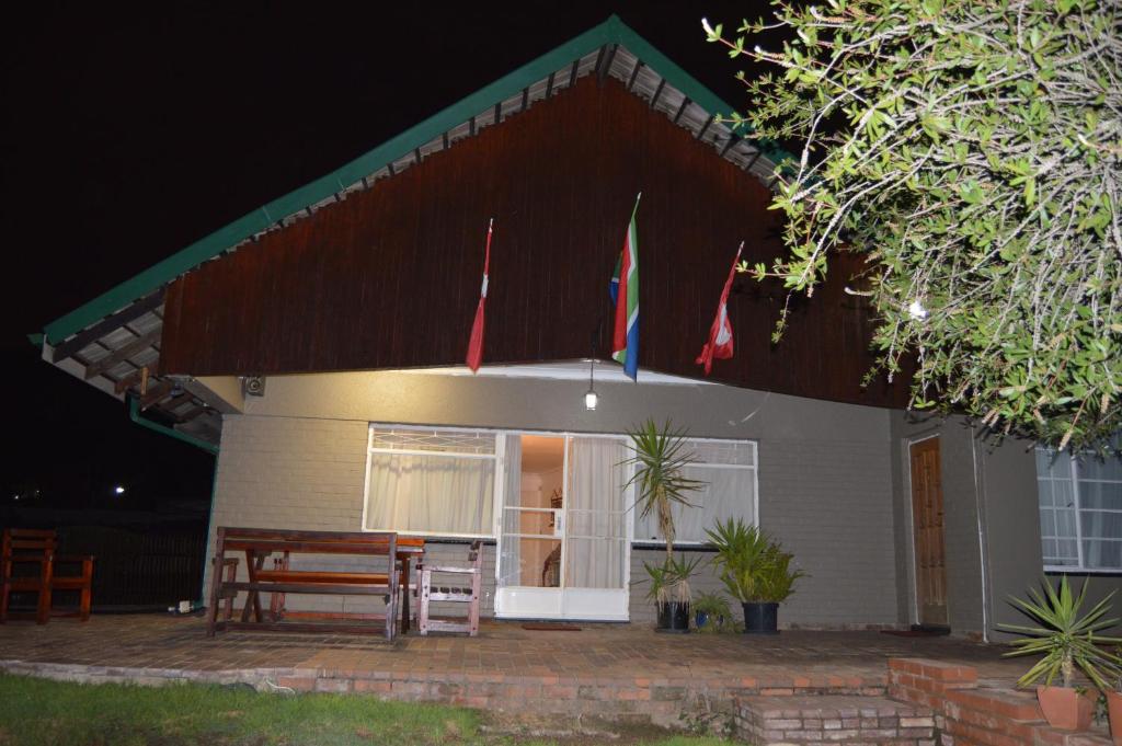 una casa con un tavolo e bandiere di fronte di The Swiss Guesthouse a Johannesburg