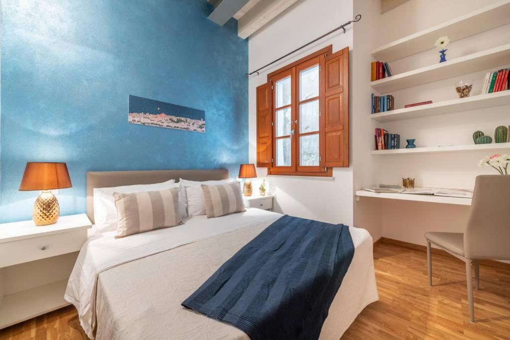 sypialnia z łóżkiem i niebieską ścianą w obiekcie Mirtì boutique Apartment heart Cagliari w Cagliari