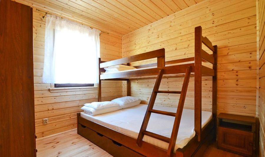 a bedroom with a bunk bed in a wooden cabin at Domki u Małgosi in Rusinowo