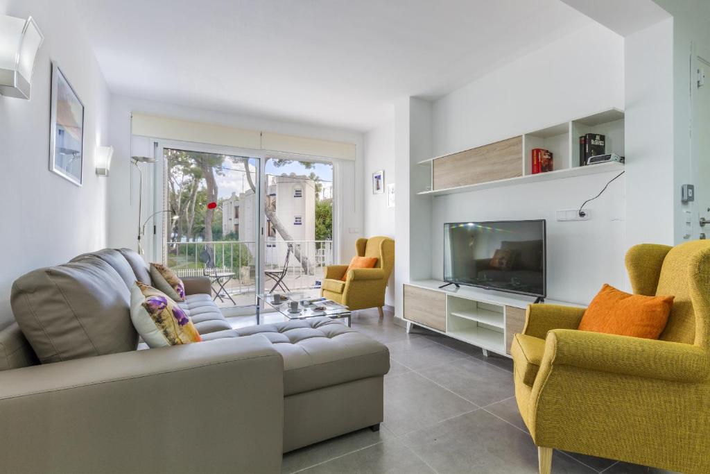 a living room with a couch and two chairs and a television at Apartment Assimetric - Only 100m to Beach in Alcudia