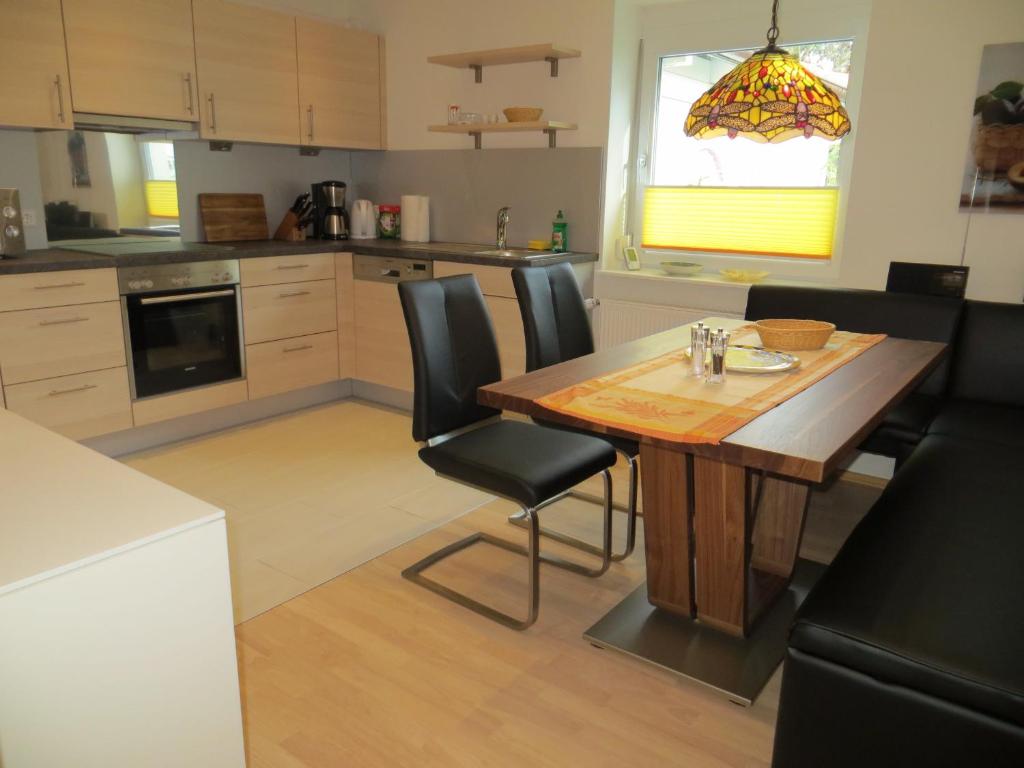 une cuisine avec une table en bois et des chaises noires dans l'établissement Ferienwohnungen Familie Schwarze, à Grenzach-Wyhlen