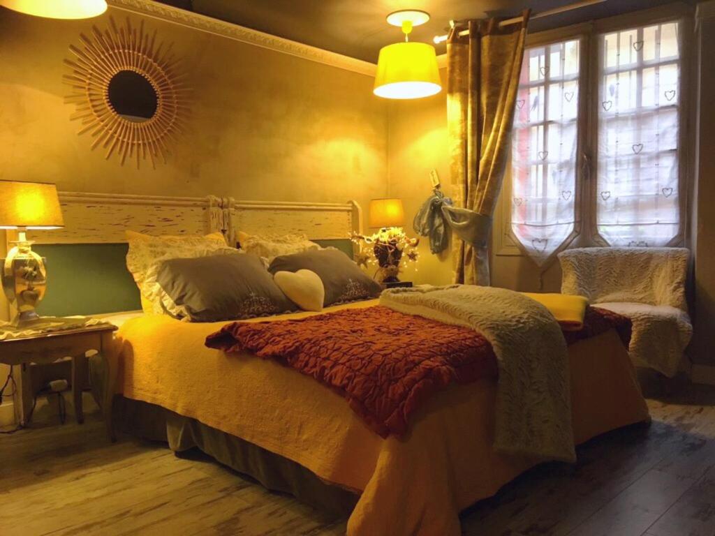 - une chambre avec un lit, une table et des fenêtres dans l'établissement La Parenthèse, à Casteljaloux