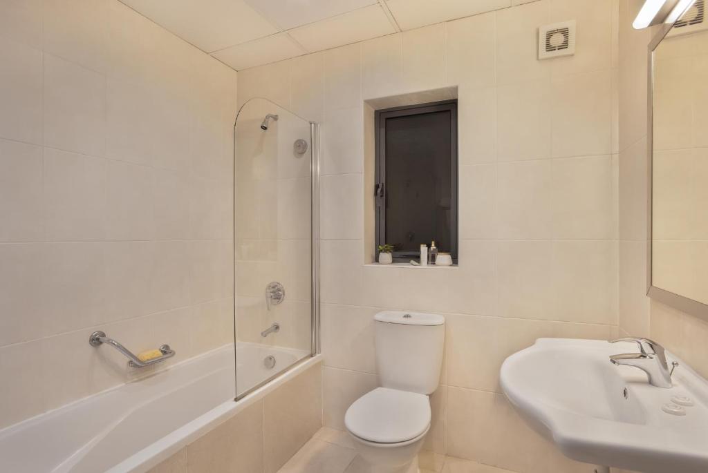 a bathroom with a toilet and a sink and a shower at Plaza Regency Hotels in Sliema