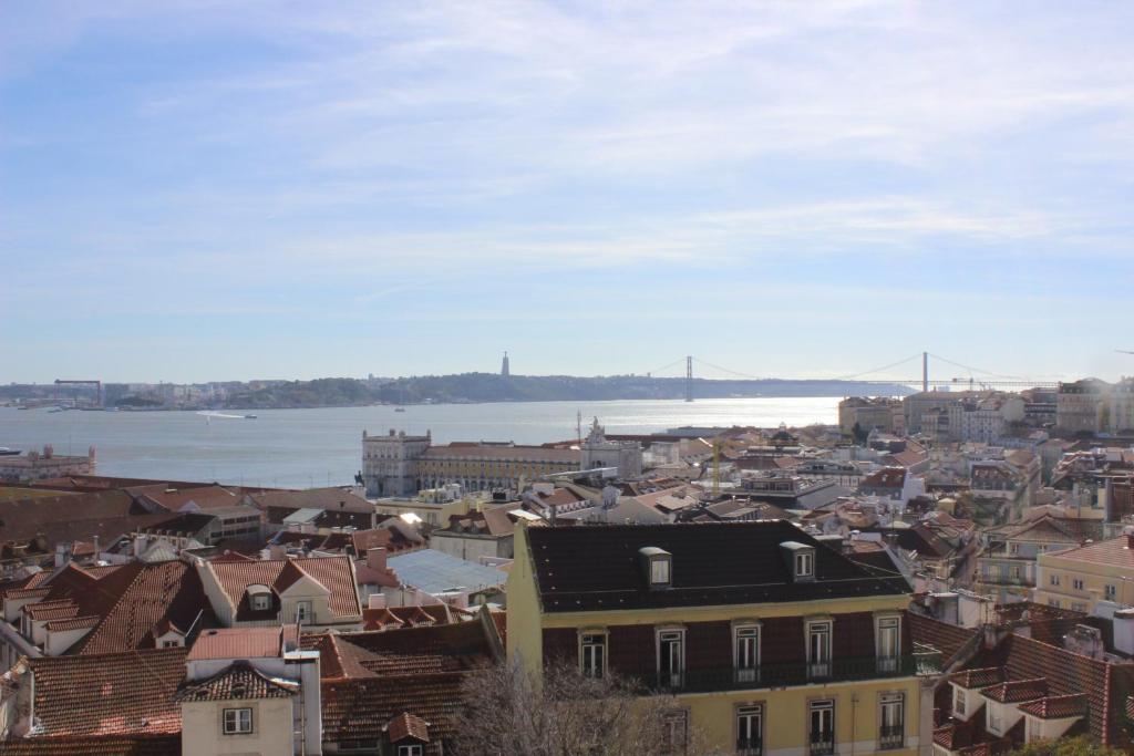 een stad met gebouwen en een brug op de achtergrond bij Retrato de Lisboa in Lissabon