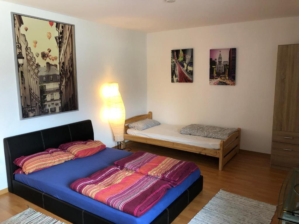 a bedroom with a bed and a small bed and a table at Apartment Hope Inn in Groß-Zimmern