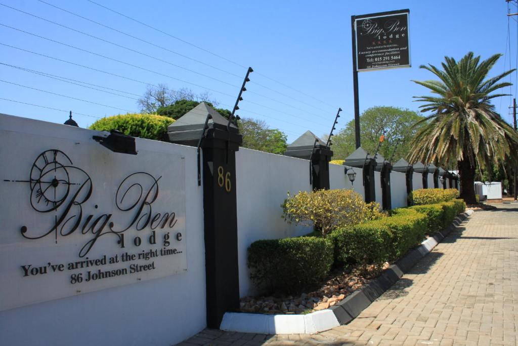 a fence with a sign that says join iron studios at Big Ben Lodge in Polokwane
