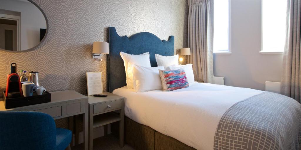 ein Schlafzimmer mit einem Bett, einem Schreibtisch und einem Spiegel in der Unterkunft 54 Queen's Gate Hotel in London