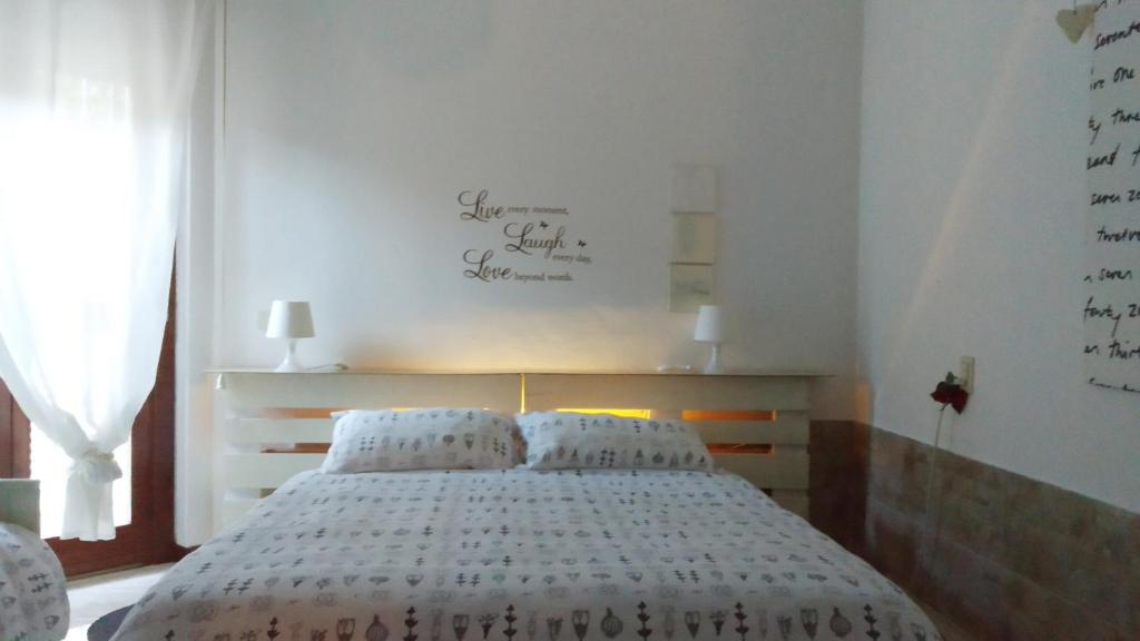 a bedroom with a white bed with two pillows at Holiday Home Bergamo 1 in Bergamo