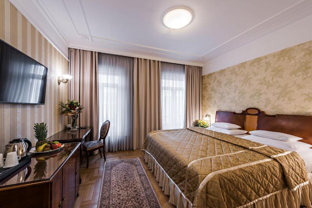 a hotel room with a large bed and a desk at Hotel Moskva in Belgrade