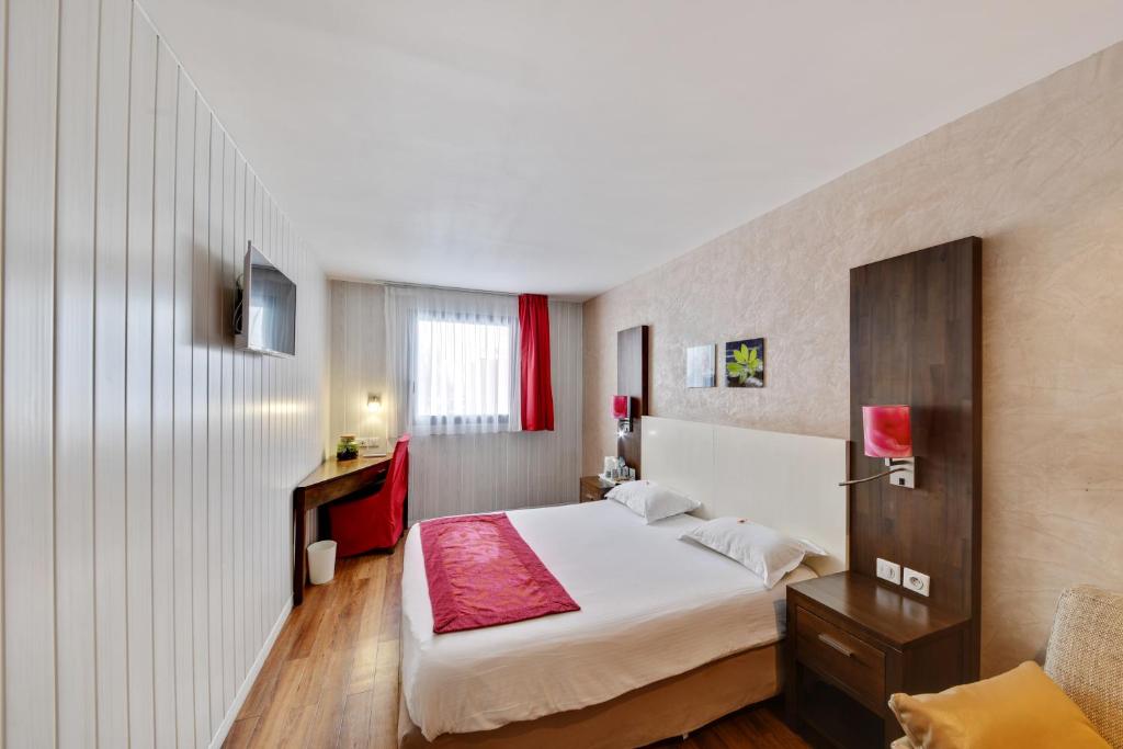 ein Schlafzimmer mit einem großen weißen Bett in einem Zimmer in der Unterkunft HOTEL PARIS PACIFIC VILLEJUIF- INSTITUT GUSTAVE ROUSSY ORLY RUNGIS BUS 131 Direct PARIS in Villejuif