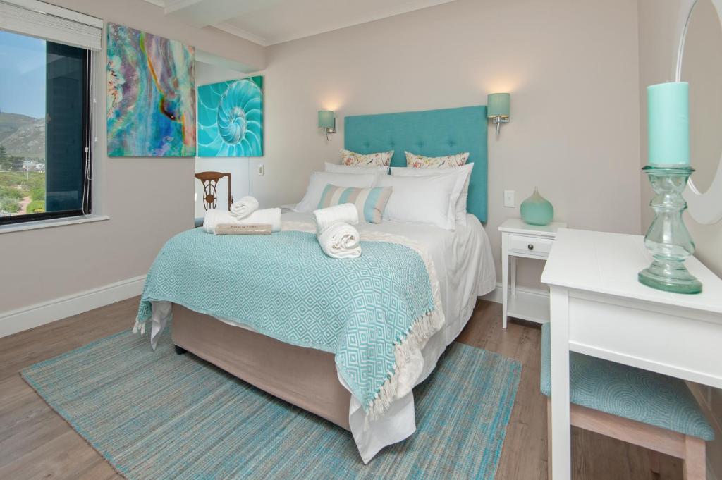 a bedroom with a large bed and a window at The Sun,Whales and Waves seafront apartment in Hermanus