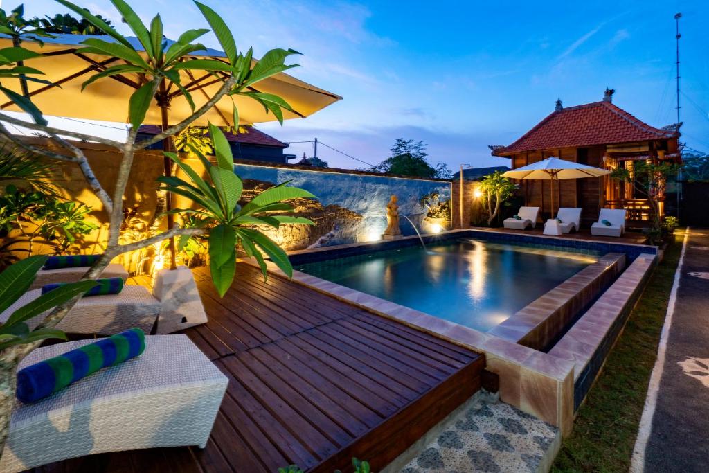 a backyard with a pool and a wooden deck at Radiance Sunset Villas Lembongan in Nusa Lembongan