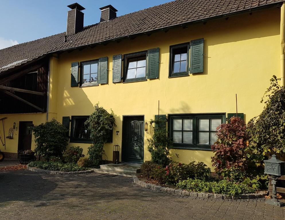 una casa amarilla con ventanas negras y una puerta en Apartments Luisenhof, en Krefeld