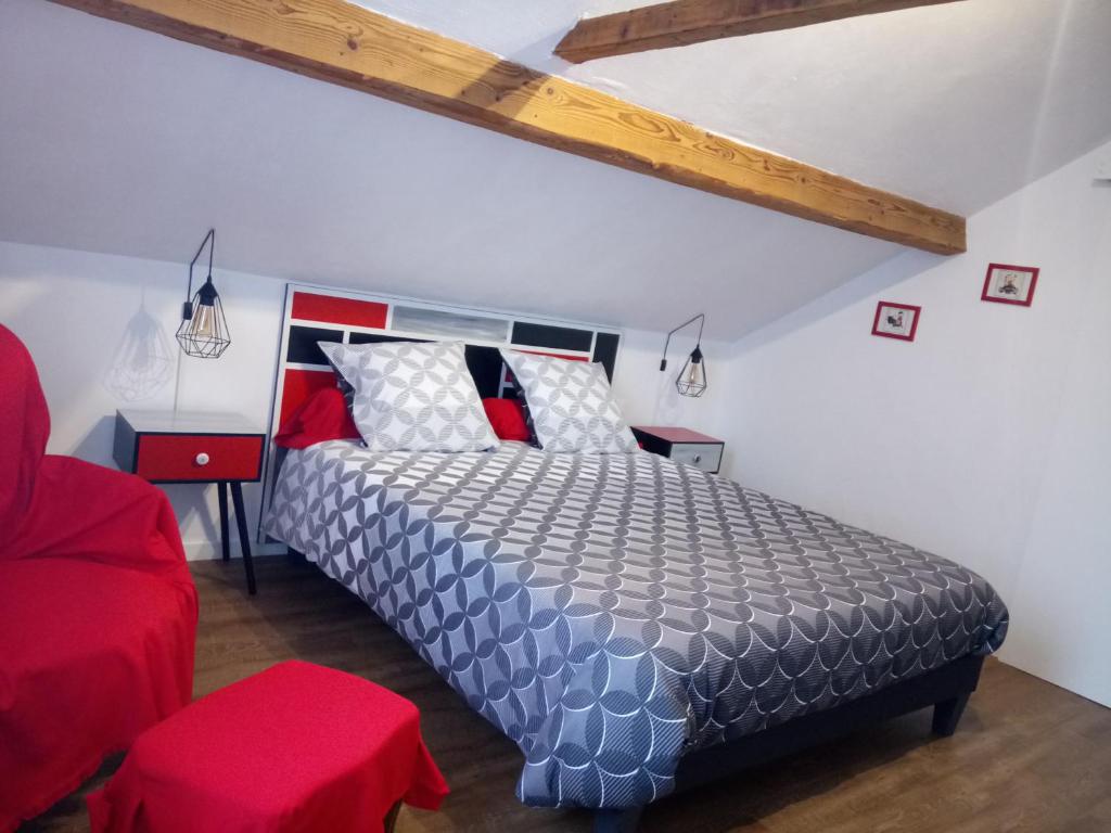 1 dormitorio con 1 cama y 1 silla roja en Chambres d'hôtes Toulaho, en Cazères