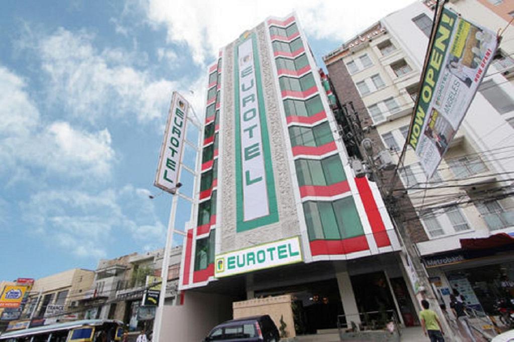 a tall building with a sign in front of it at Eurotel Angeles in Angeles