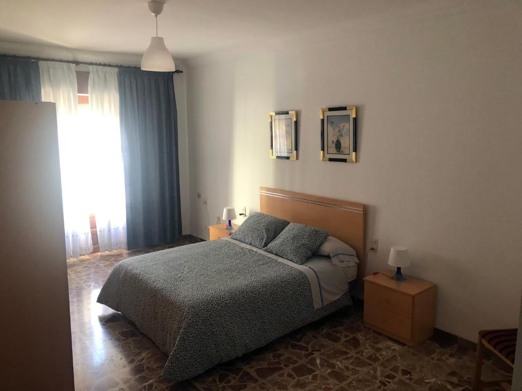 a bedroom with a bed with two pillows and a window at Home Sancle in San Clemente