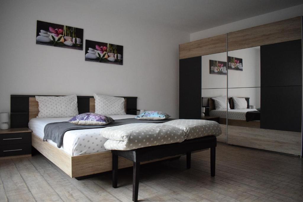 ein Schlafzimmer mit einem Bett und einem großen Spiegel in der Unterkunft Bruno Apartment in Cluj-Napoca