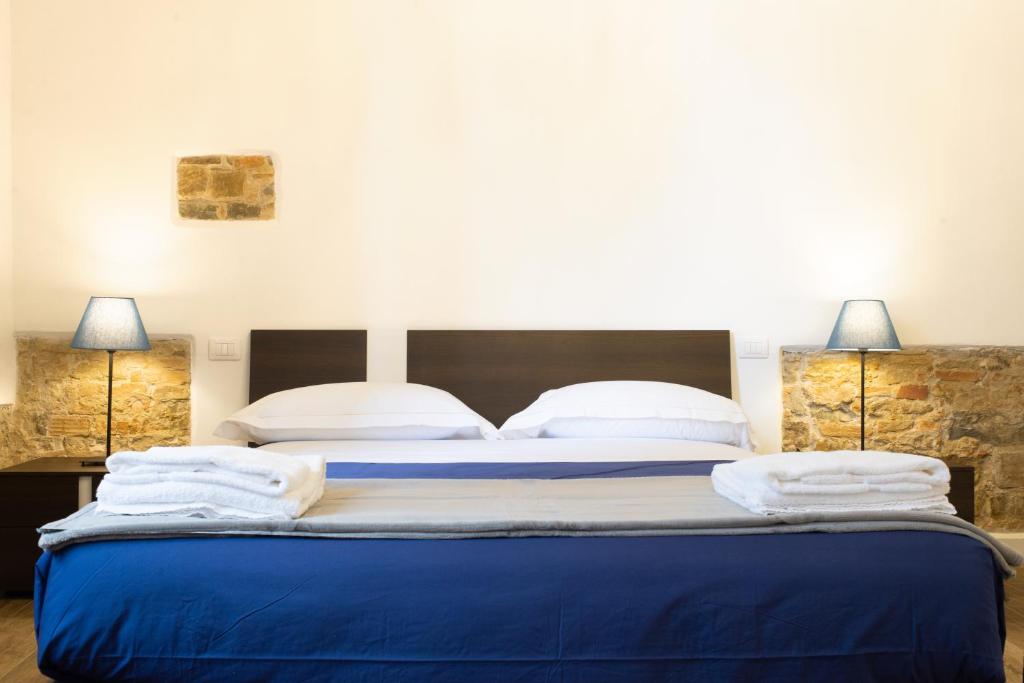 een slaapkamer met een groot blauw bed met 2 lampen bij Bellavista Lux Ground Floor Apt in Florence