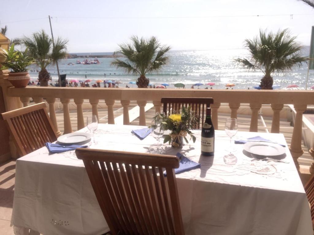 a dining table with a view of the beach at Precioso piso frente al mar con enorme terraza in El Campello