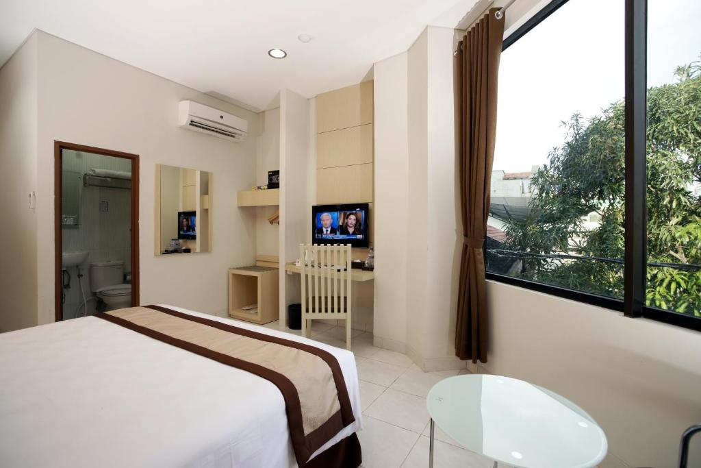a bedroom with a bed and a large window at Hotel 88 - Mangga Besar VIII Jakarta By WH in Jakarta