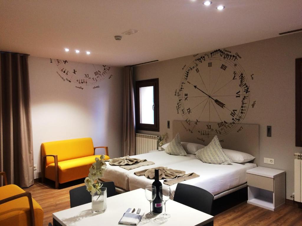 une chambre d'hôtel avec une grande horloge sur le mur dans l'établissement Apartamentos Turísticos Pueri Cantores, à Burgos
