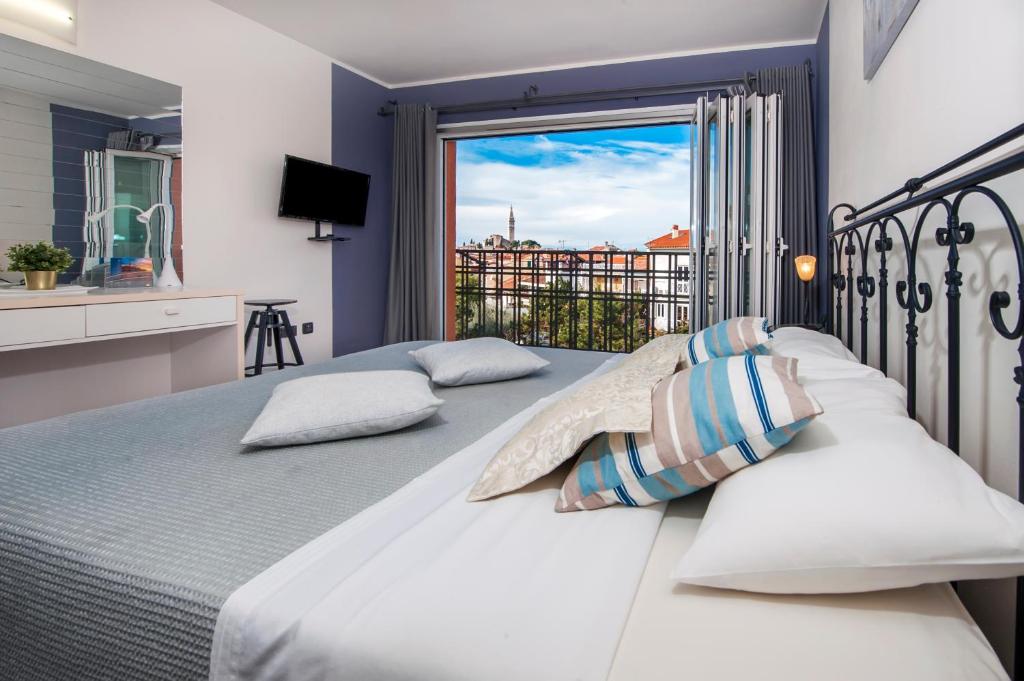 um quarto com uma cama grande e uma janela em Guesthouse Bellavista em Rovinj