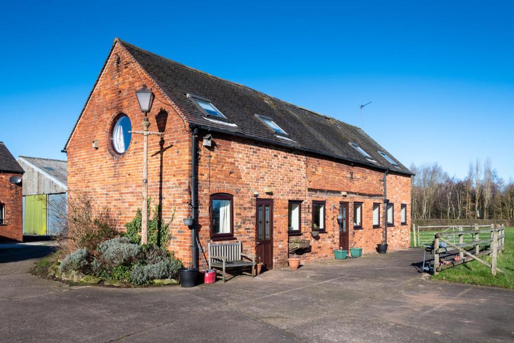 un edificio de ladrillo con un banco delante de él en Common Farm Motel, en Stafford