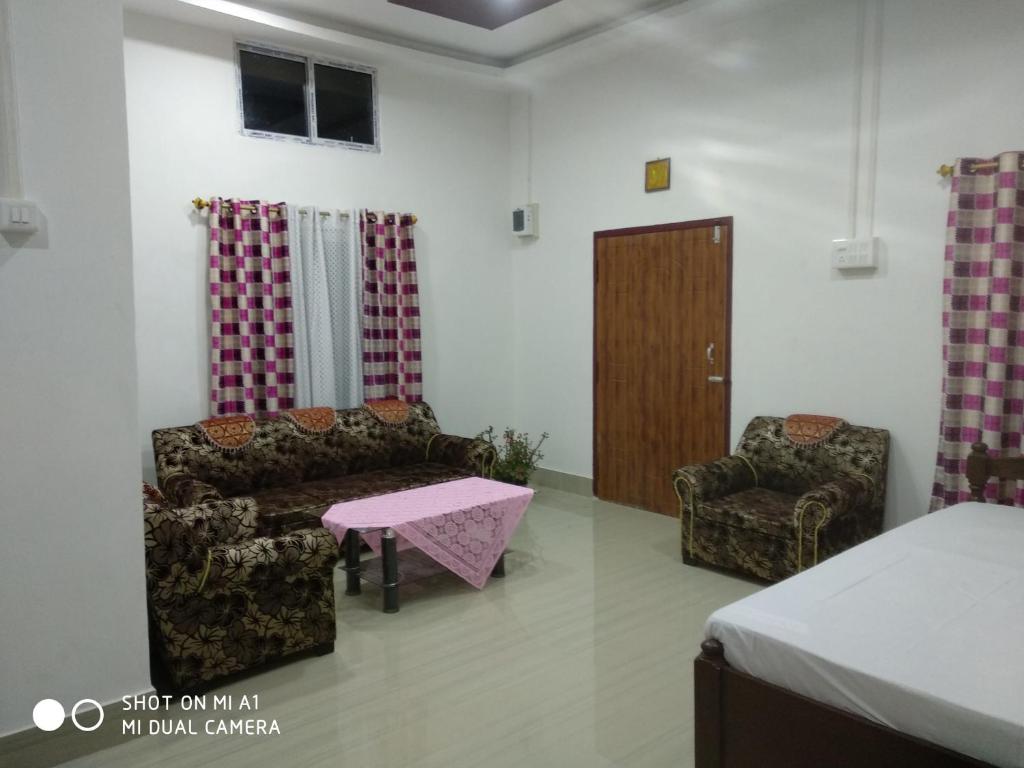 a room with a couch and a chair and a table at "Dulce Hogar" homestay in Majuli