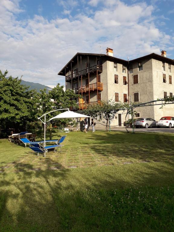 a building with a park with benches in the grass at Residence Gemma in Riva del Garda