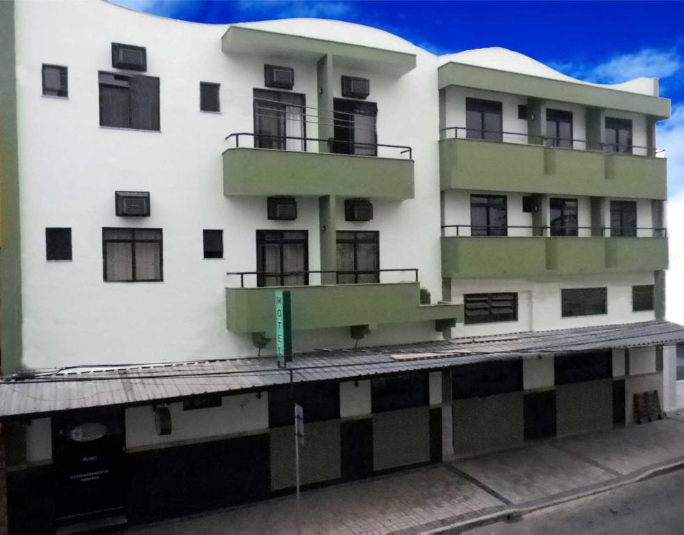 een wit gebouw met balkons aan de zijkant bij Hotel Olivier in Três Rios