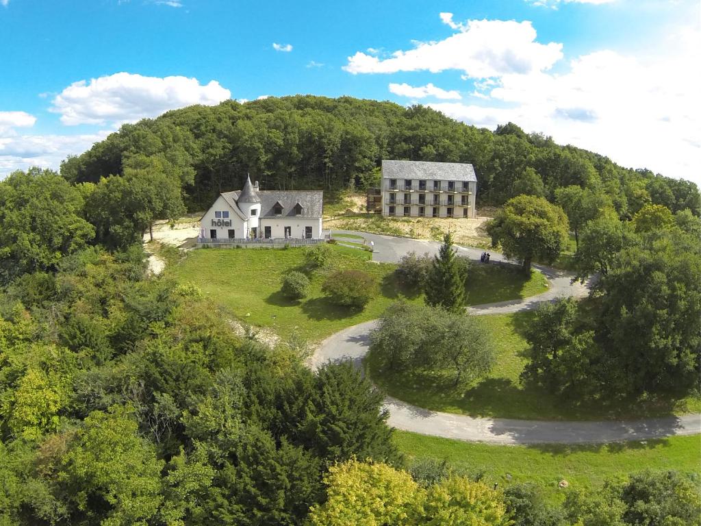 Vue aérienne d'une maison sur une colline dans l'établissement LOGIS Hôtel-restaurant IMAGO, à La Roche-Clermault