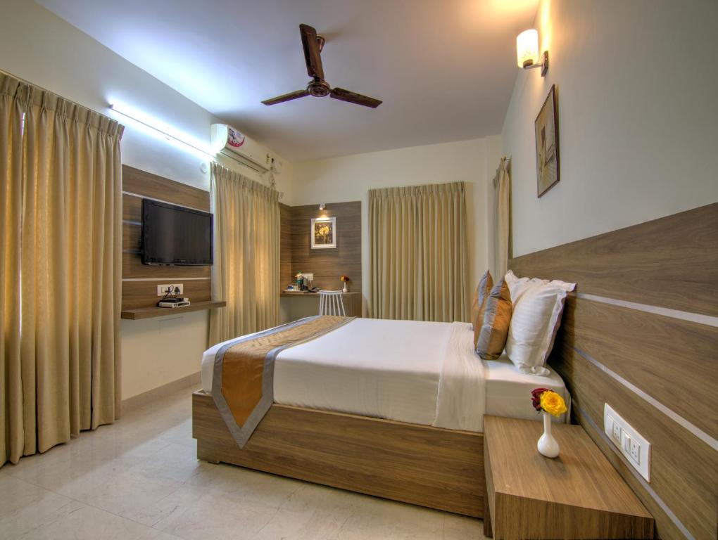 una habitación de hotel con una cama y un televisor en Sunshine Suites Grand Deluxe, en Bangalore