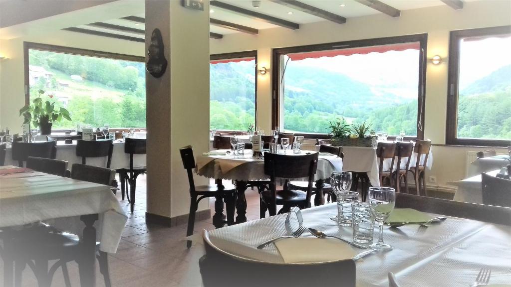 Le Falgoux的住宿－hotel restaurant des voyageurs，餐厅设有桌椅和大窗户。