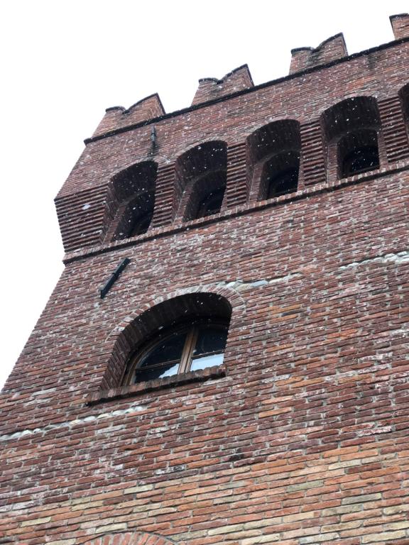 una torre di un orologio di mattoni alto con due finestre sopra di Il Feudo Di Agnadello ad Agnadello