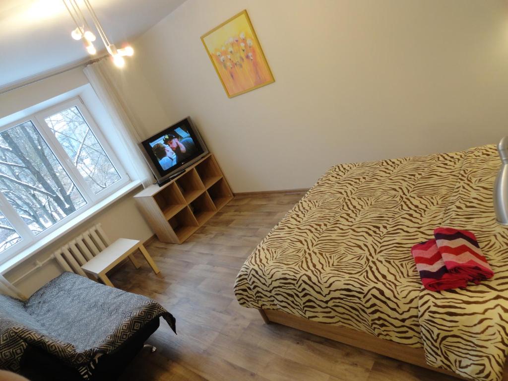 Apartment Arena Riga quiet center FREE PARKING في ريغا: غرفة نوم فيها سرير وتلفزيون