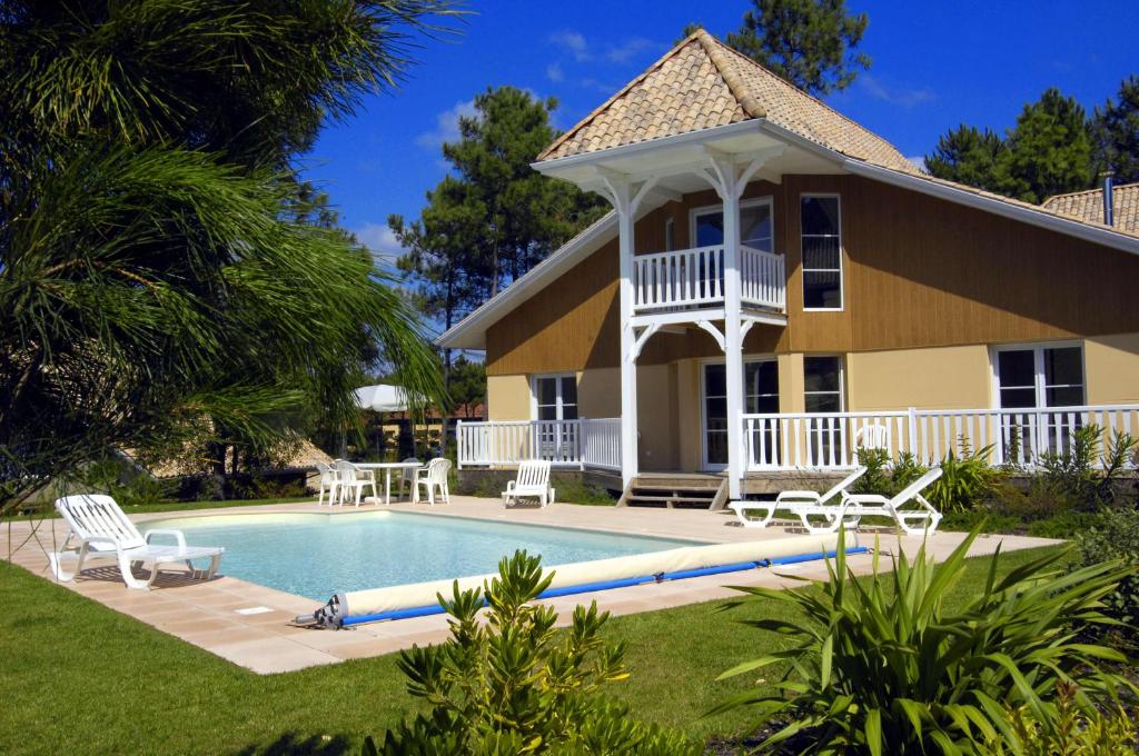 a house with a swimming pool in the yard at Lagrange Vacances - Eden Club in Lacanau-Océan