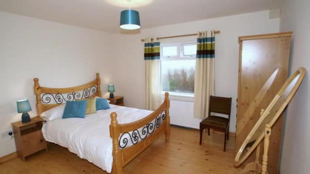 a bedroom with a bed and a chair and a window at Three bedroom holiday home in Port