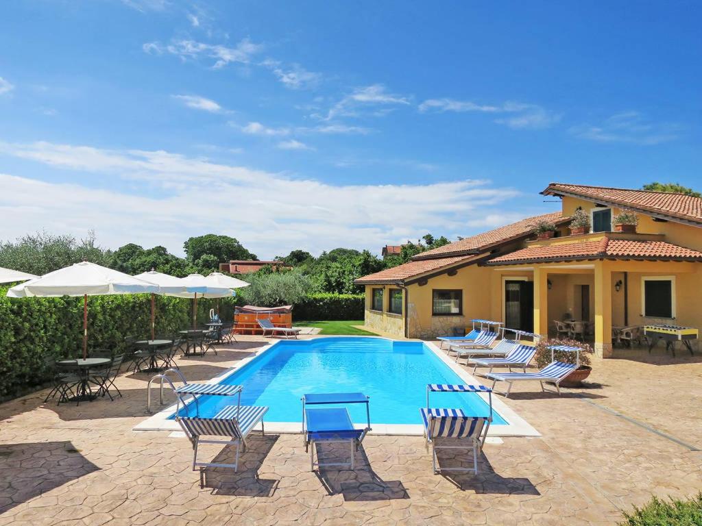 einen Pool mit Stühlen und Sonnenschirmen neben einem Haus in der Unterkunft L'Infinito in Carbognano