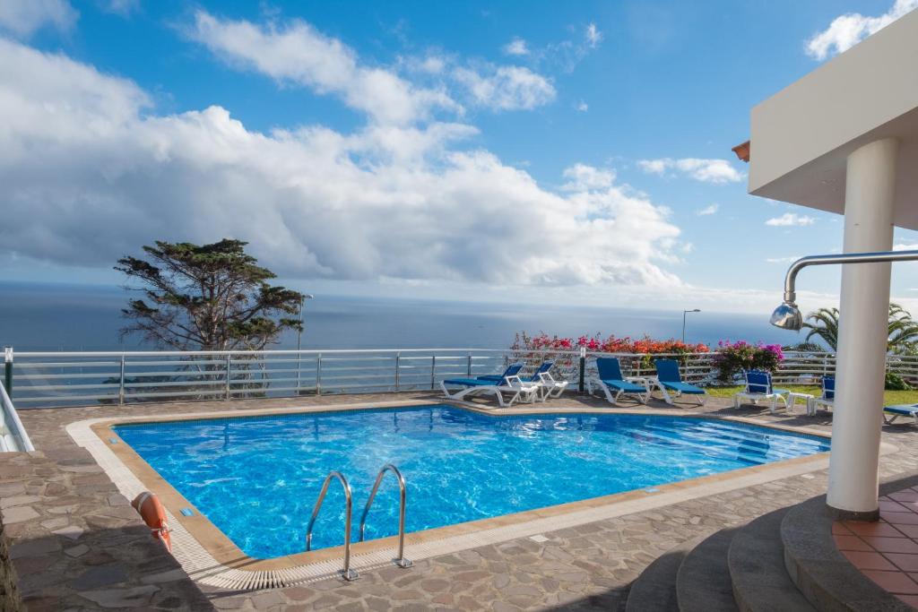 a swimming pool with a view of the ocean at Apartments Madeira in Caniço