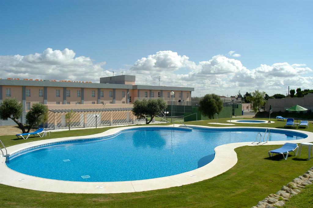 einem großen Pool vor einem Gebäude in der Unterkunft Gran Hotel Ciudad Del Sur in Puerto Real